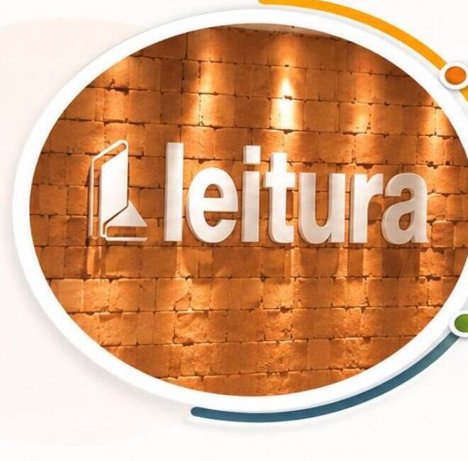 Logotipo do curso: Leitura, sobre parede de tijolos iluminada